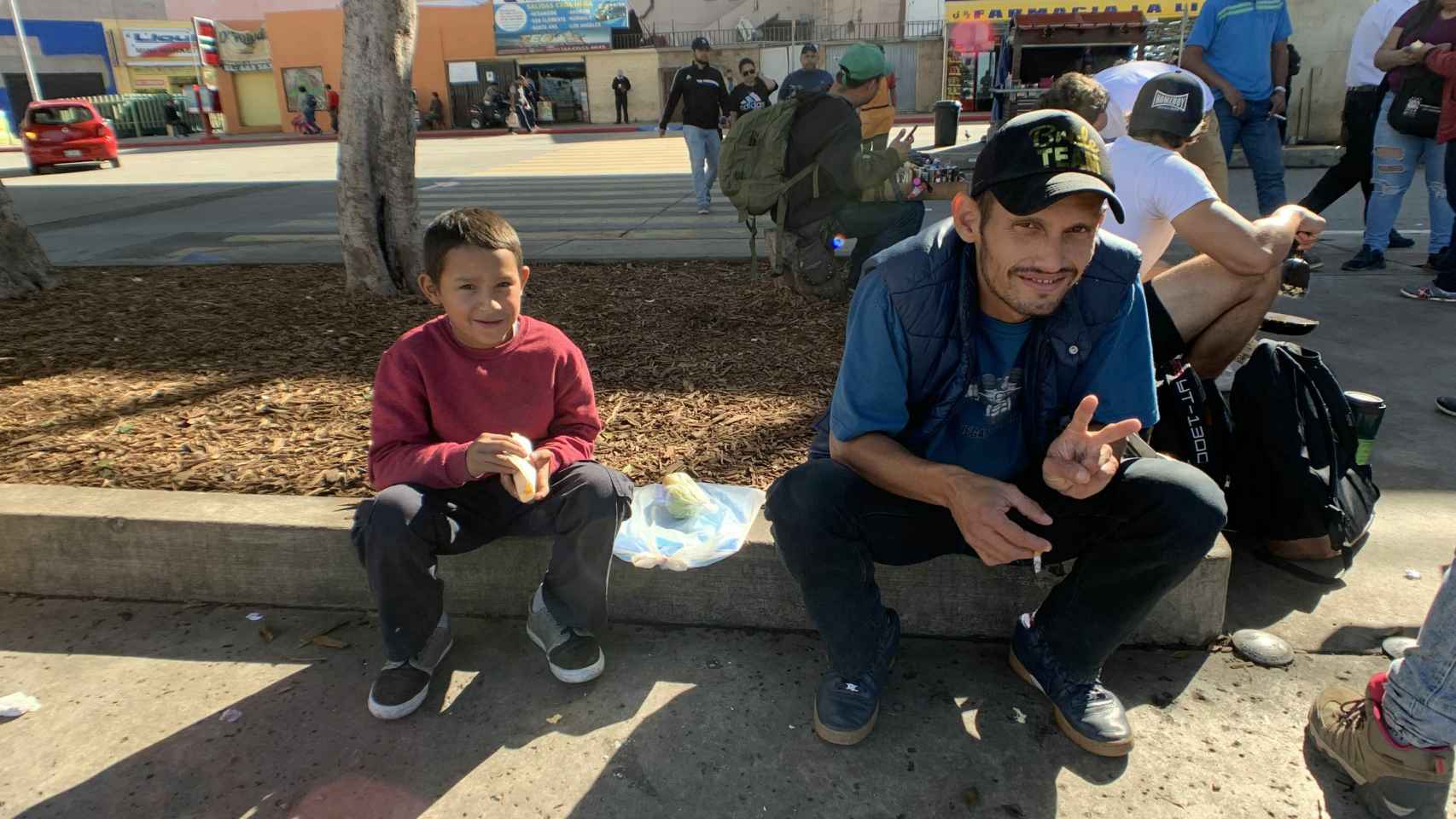 Un niño y un hombre, pertenecientes a la caravana, sentados en la calle.