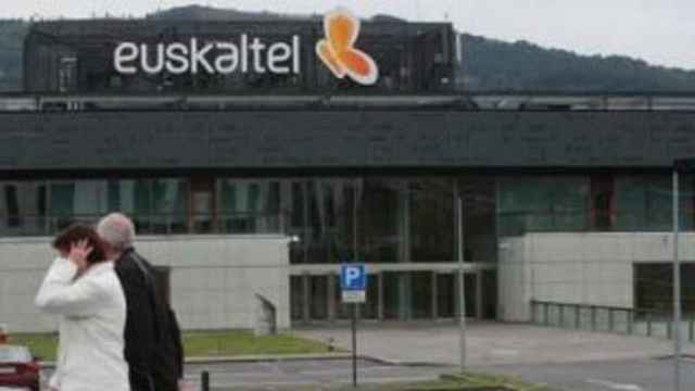 Dos personas  pasean ante unas oficinas de Euskaltel.