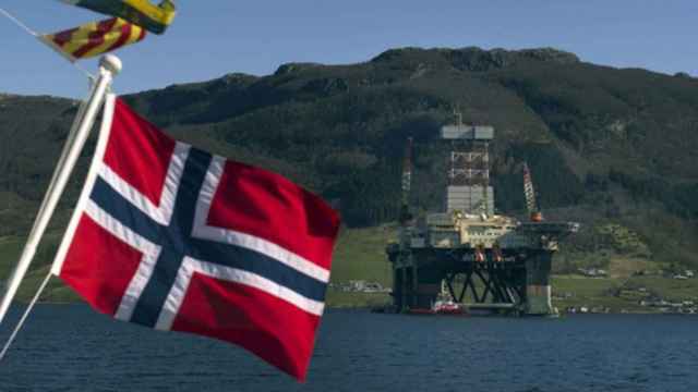 La bandera de Noruega frente a una plataforma petrolera.
