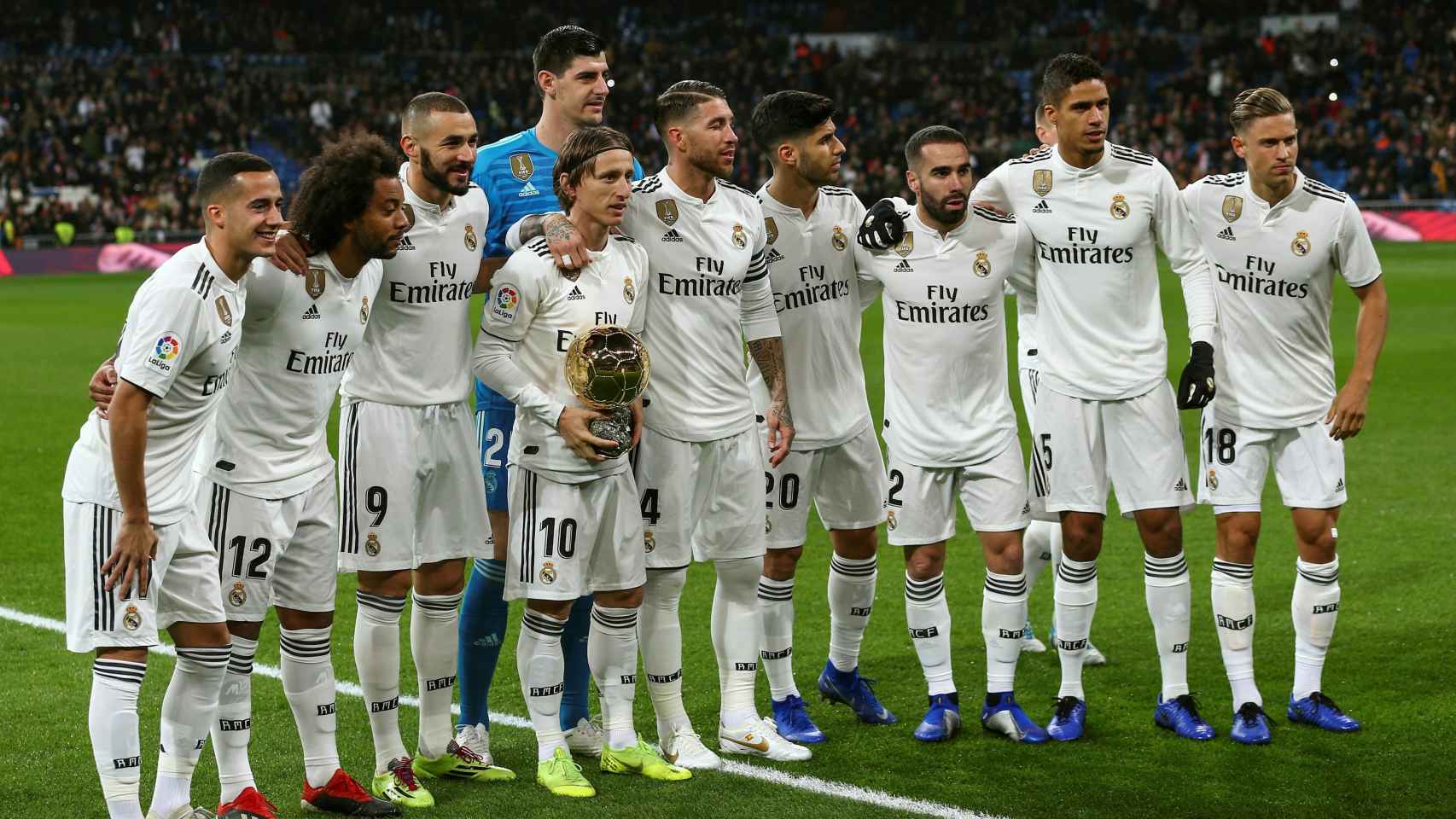 El centrocampista croata del Real Madrid Luka Modric muestra, rodeado de sus compañeros, el trofeo del Balón de Oro al público