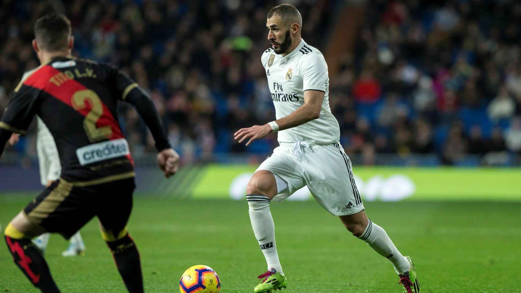 Karim Benzema pelea un balón con el defensa del Rayo Vallecano Roberto Román Tito