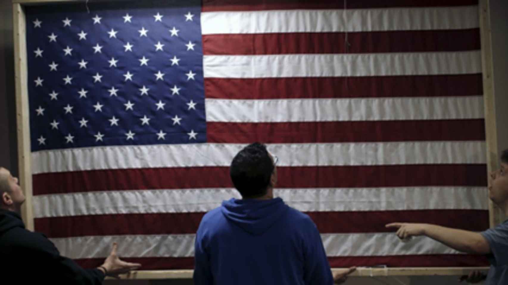 Unos jóvenes sostienen una bandera de EEUU.