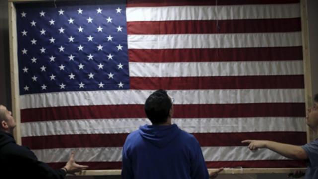 Unos jóvenes sostienen una bandera de EEUU.
