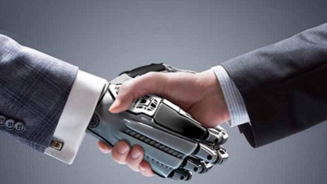 Un inversor estrecha una mano biónica de un robot.