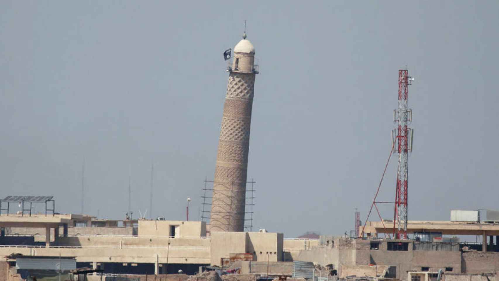 Minarete de la mezquita con la bandera de Estado Islámico tras destruirla.