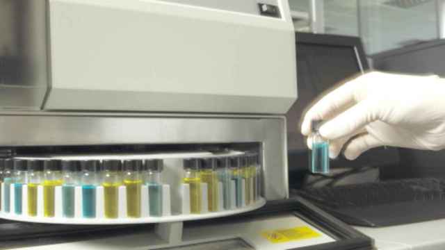 Un trabajador maneja muestras en un laboratorio.