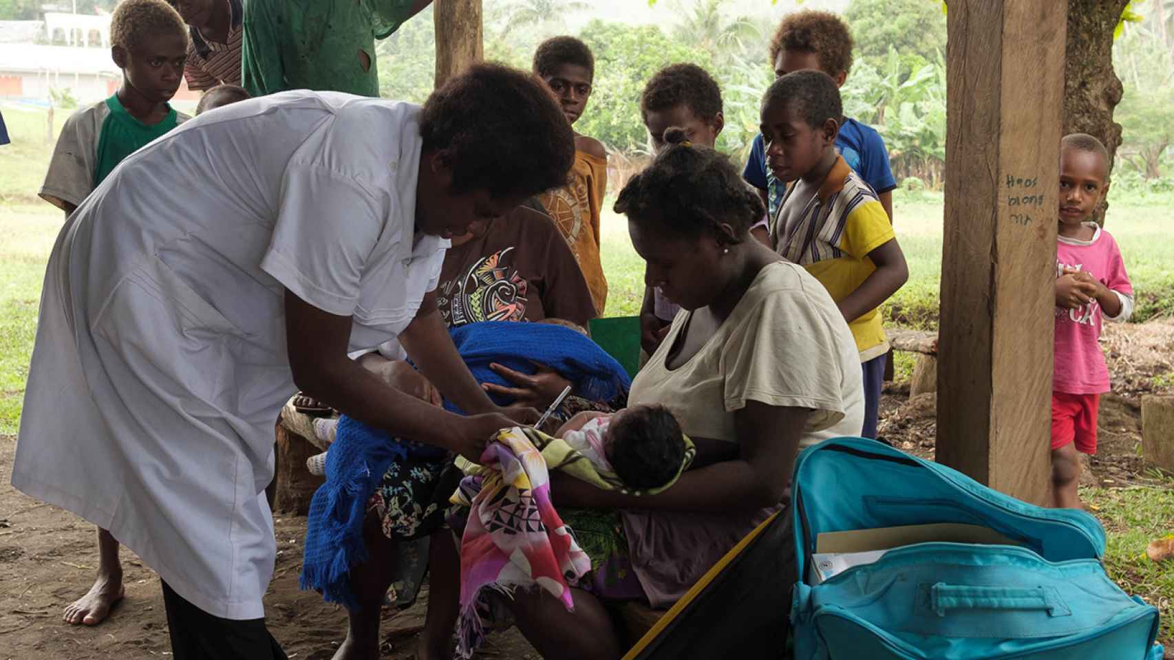 Una de las enfermeras poniendo una vacuna a un niño de Vanuatu.