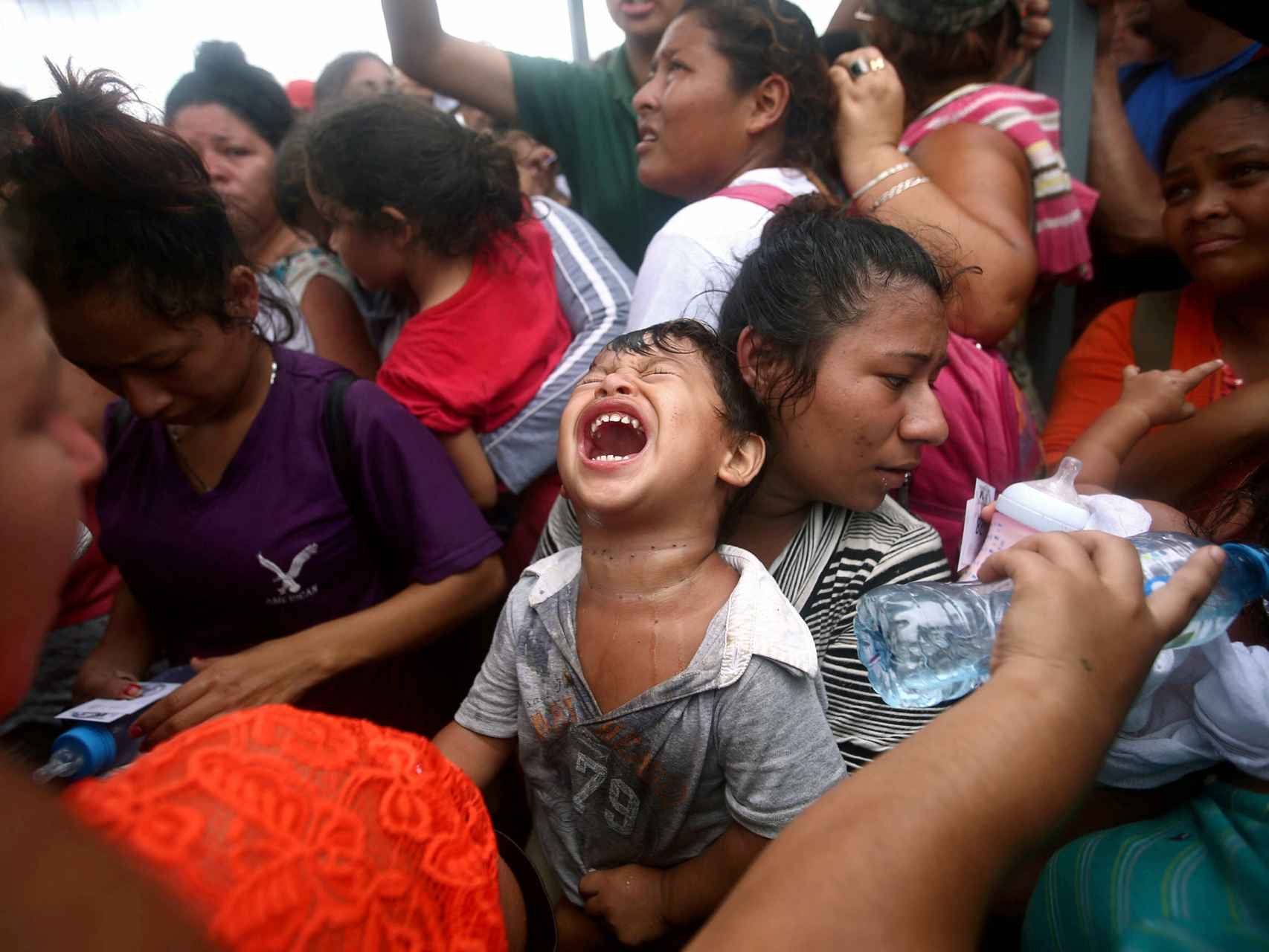 Un niño en brazos de su madre en una caravana de migrantes.