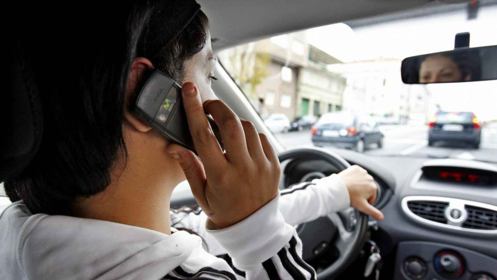Un conductor usa el móvil mientras conduce.