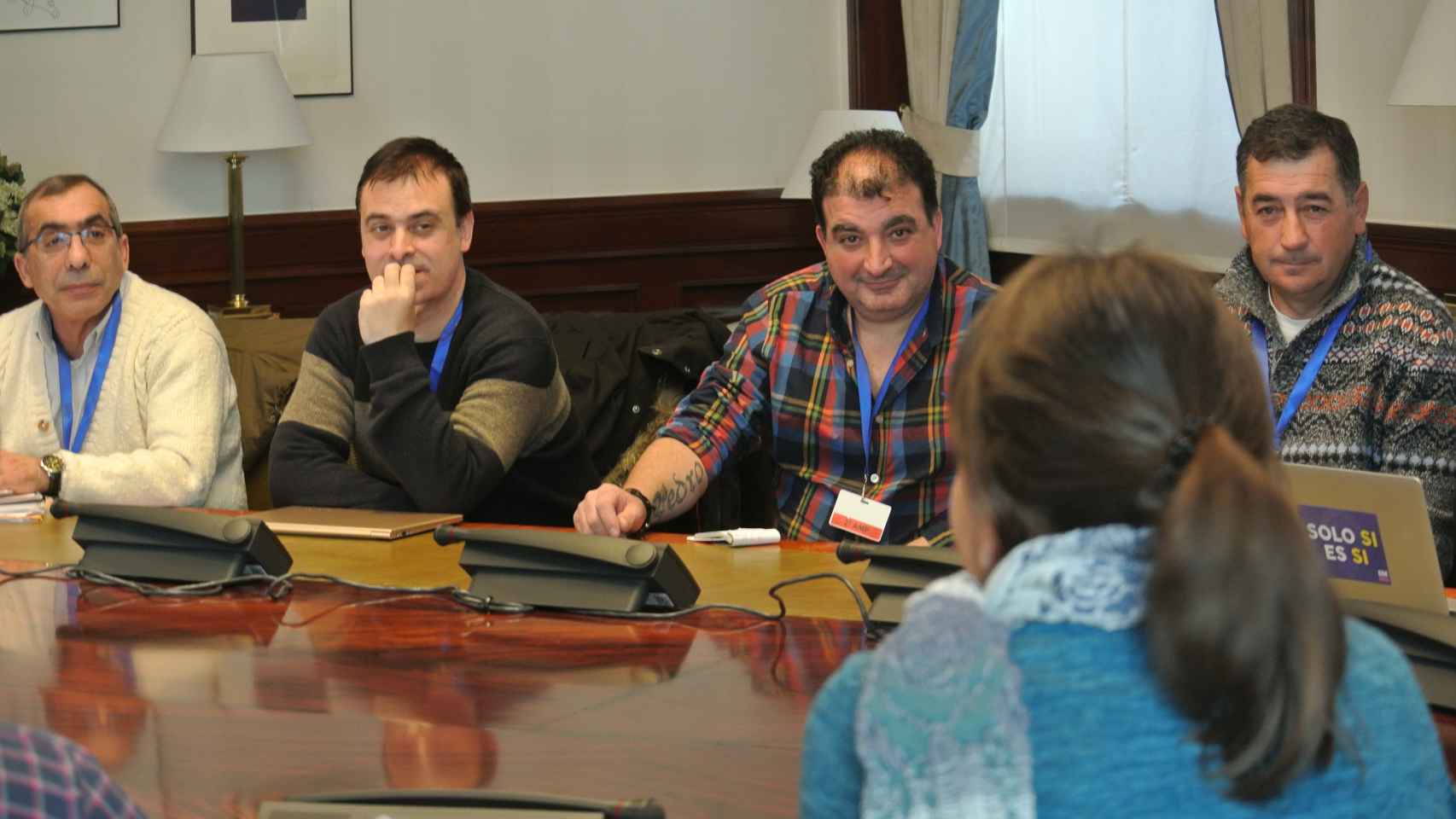 Trabajadores de subcontratas mineras reunidos con los diputados de Podemos en una sala del Congreso.
