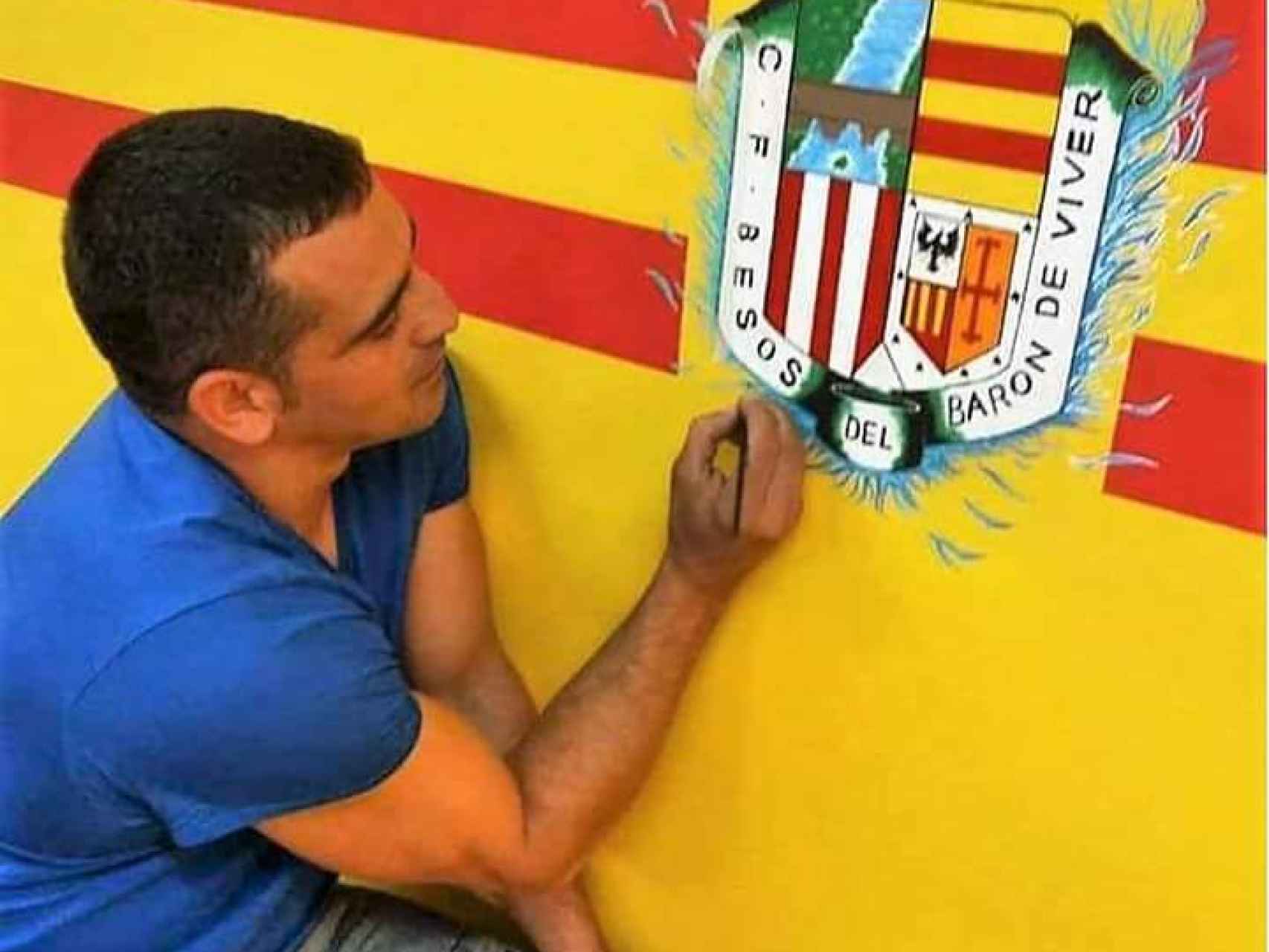Edu Colmena pintando el escudo del equipo de fútbol de su barrio