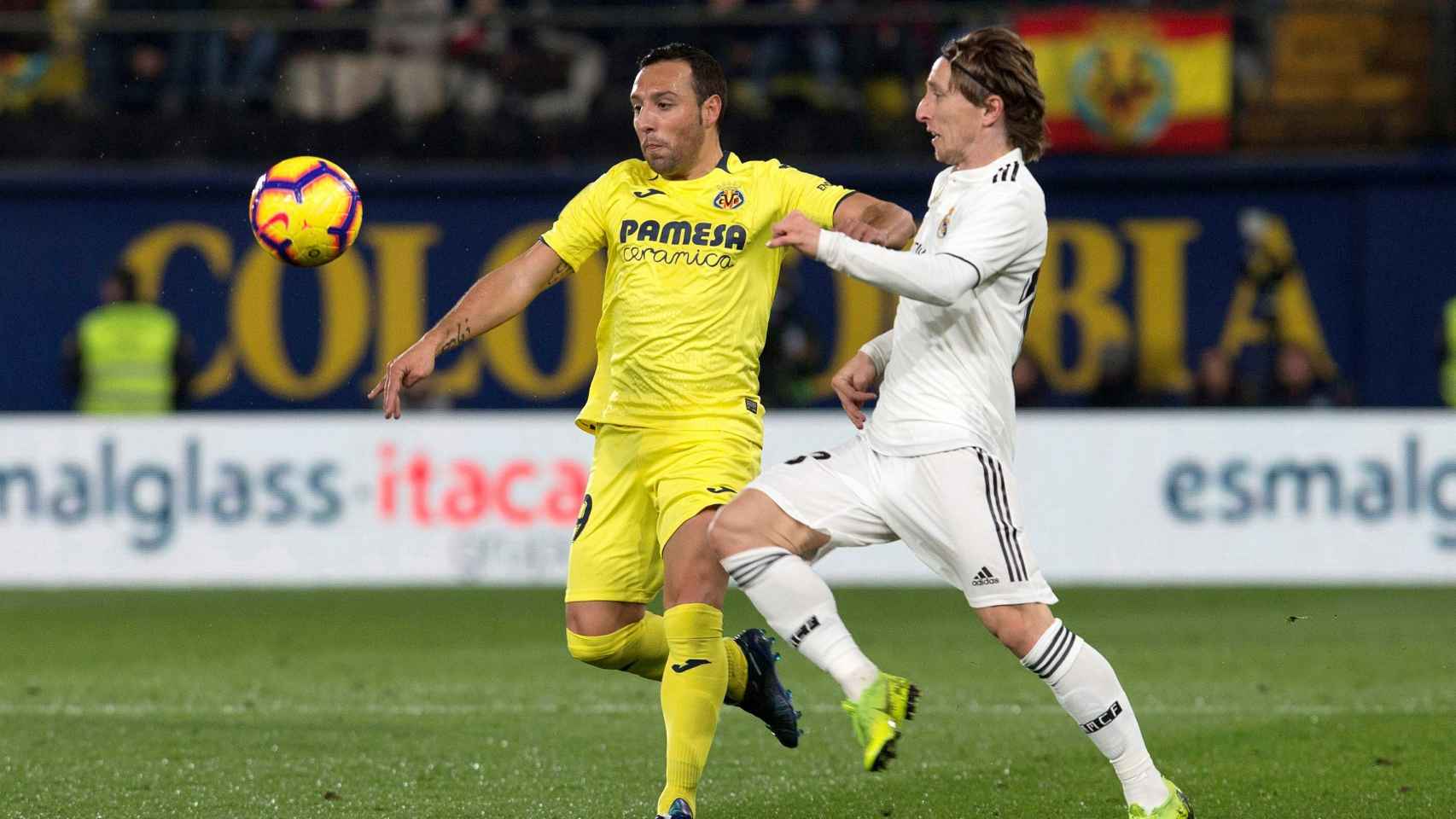 Luka Modric lucha con Santi Cazorla por un balón