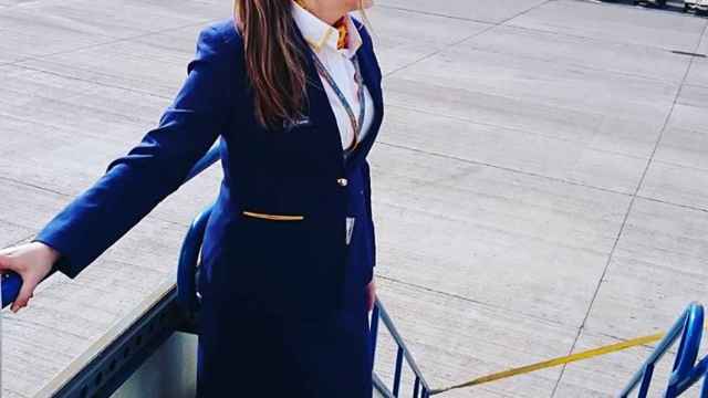 Una azafata de Ryanair a las puertas de un avión.