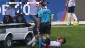 Un coche camilla pasa por encima del pie del jugador lesionado al que asistía.