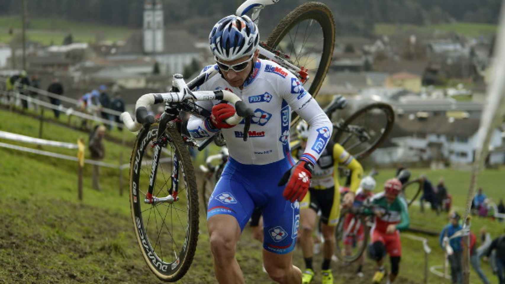 Un corredor de Ciclocross transporta su bici en el hombro