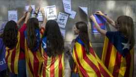 Menores de edad cuelgan carteles a favor del referéndum del 1 de octubre.