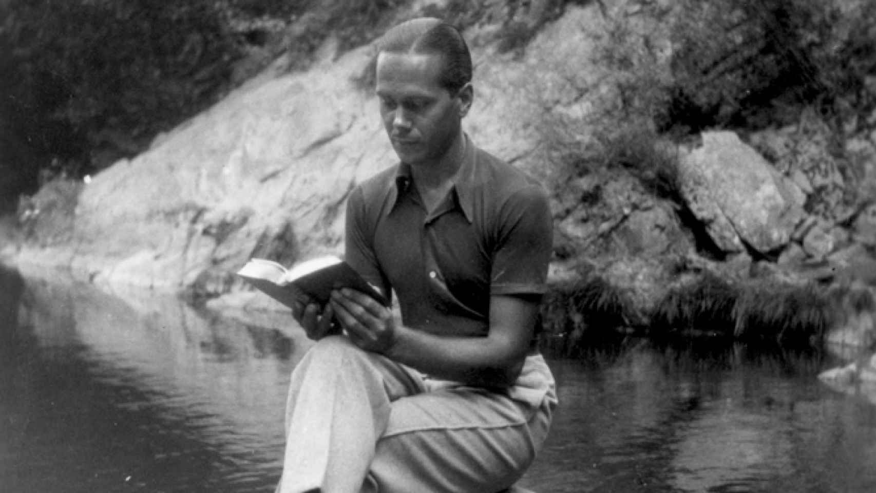 Luis Cernuda, leyendo con el río Sil a su espalda.