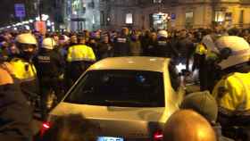 Un vehículo VTC sale escoltado por la guardia urbana de Barcelona.