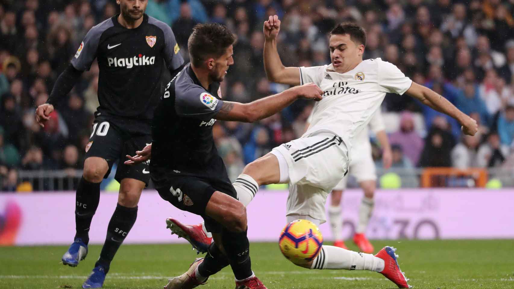 Reguilón intenta golpear un balón frente a un jugador del Sevilla