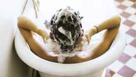 Una señorita lavándose el pelo en su bañera.