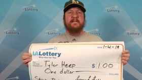 Tyler Heep posando orgulloso con el cheque que le acredita como ganador