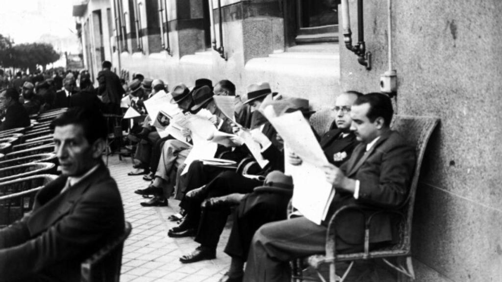 Un grupo de hombres lee el periódico en la terraza del Círuclo de Bellas Artes de Madrid.