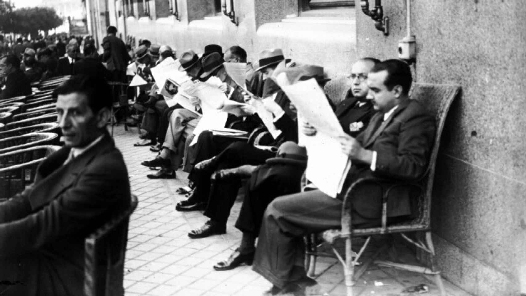 Un grupo de hombres lee el periódico en la terraza del Círuclo de Bellas Artes de Madrid.