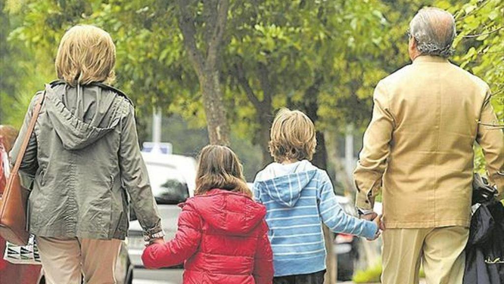 Pareja de abuelos paseando con sus nietos