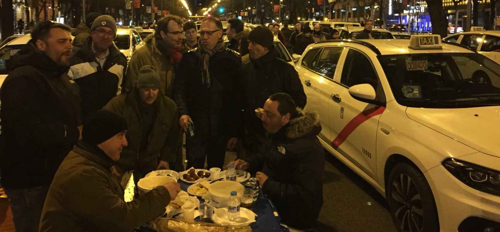 Un grupo de taxistas cenan durante la protesta