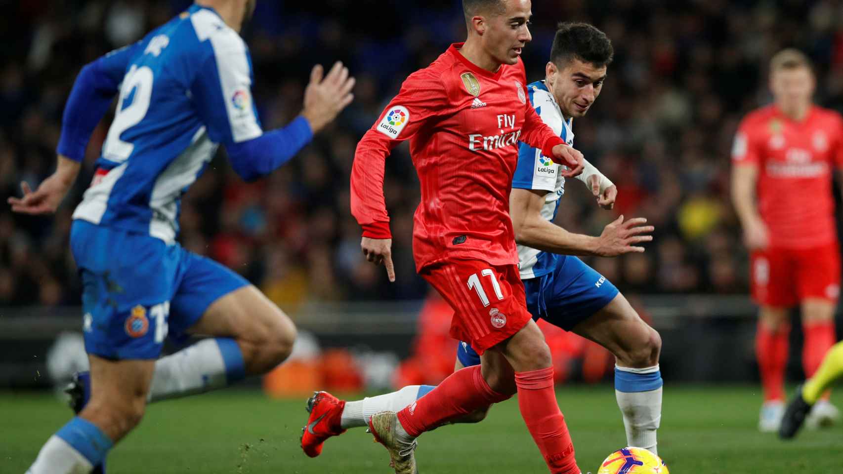 Lucas Vázquez controla el balón ante dos jugadores del Espanyol