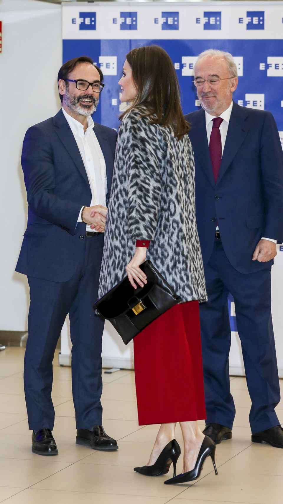La reina Letizia con cartera de Hugo Boss saludando a Fernando Garea, presidente de EFE. A la derecha, Santiago Muñoz Machado, director de la RAE.