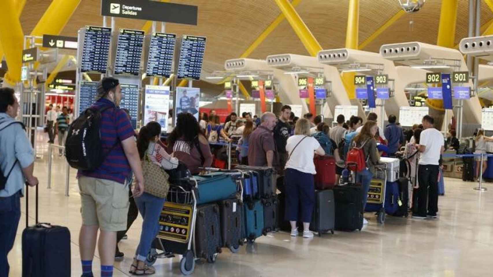 Viajeros esperando para facturar en el aeropuerto