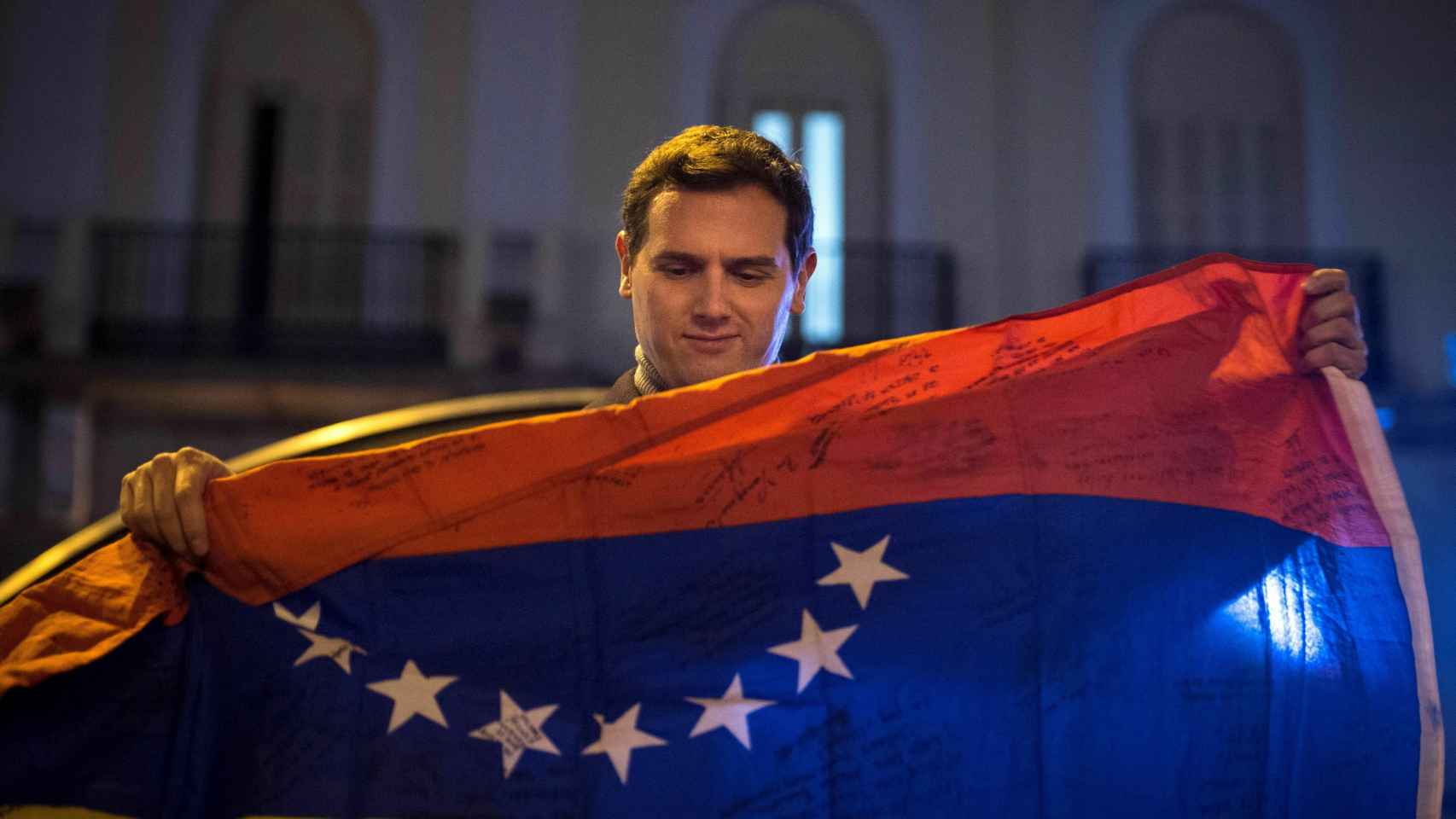 Albert Rivera sostiene una bandera de Venezuela en la concentración de la Puerta del Sol para apoyar a Juan Guaidó.