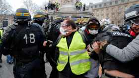 Un manifestante es retenido por varios policías en París