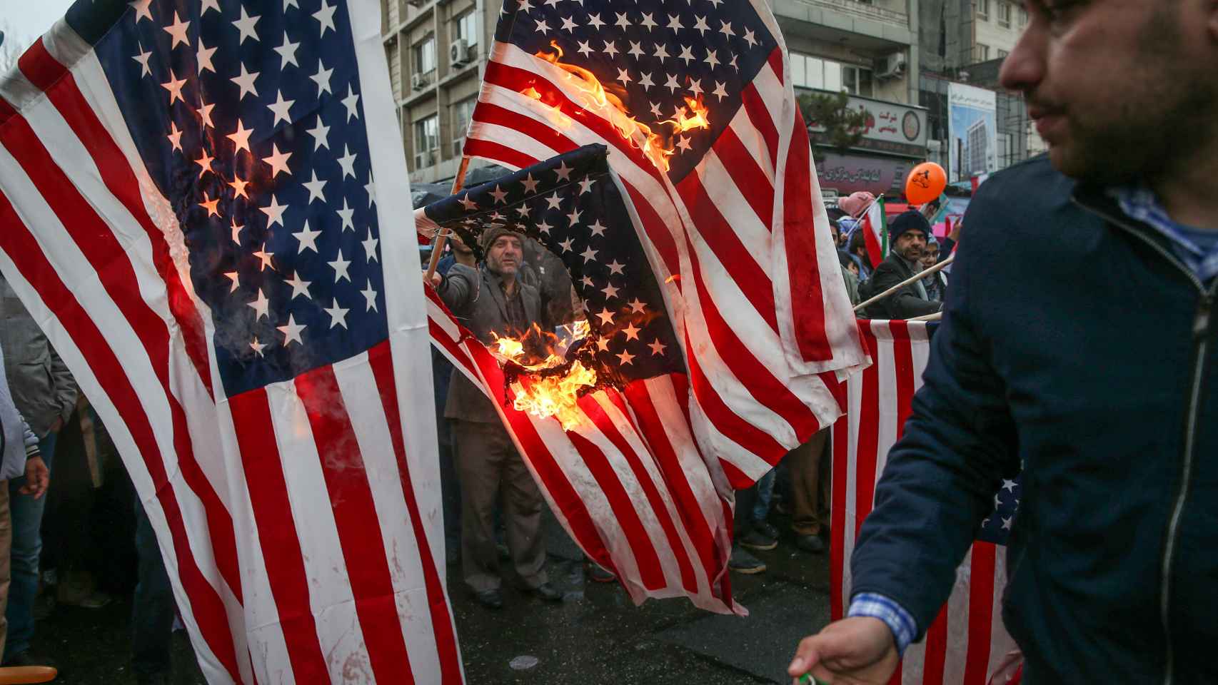 Iraníes queman banderas estadounidenses durante las celebraciones del aniversario de la revolución.