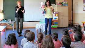 Una profesora explica, con ayuda de una intérprete de lengua de signos.