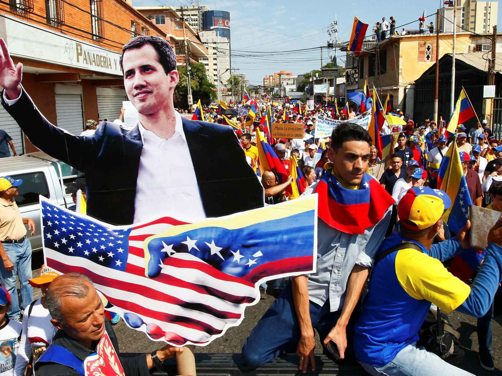 Partidarios de la oposición venezolana con un cartel de Guaidó en Caracas