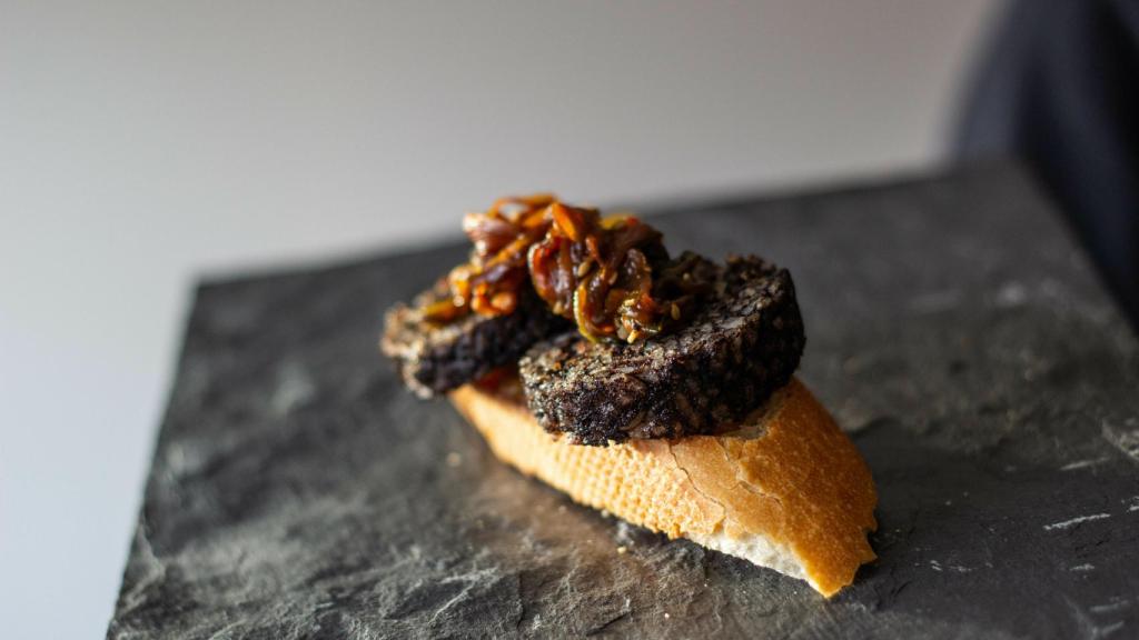 El emplatado final. Sobre la morcilla reposan unos tallarines de verduras.