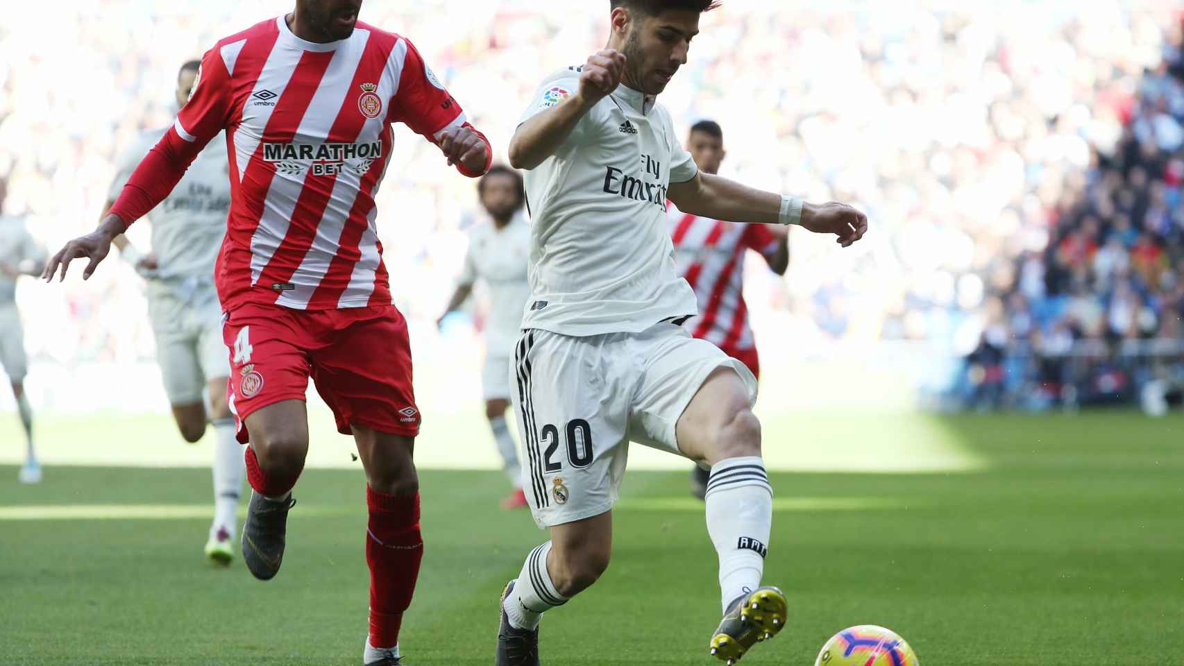 Marco Asensio controla el balón junto a un jugador del Girona