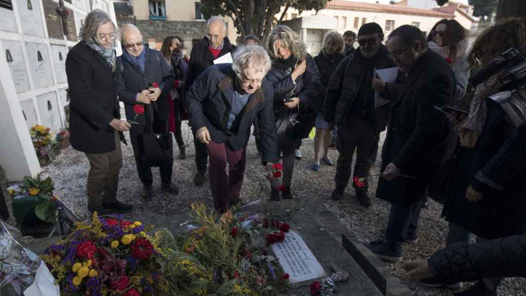 El hispanista Ian Gibson y el grupo que le acompañó en su visita a Colliure, depositan rosas en la tumba de Machado.