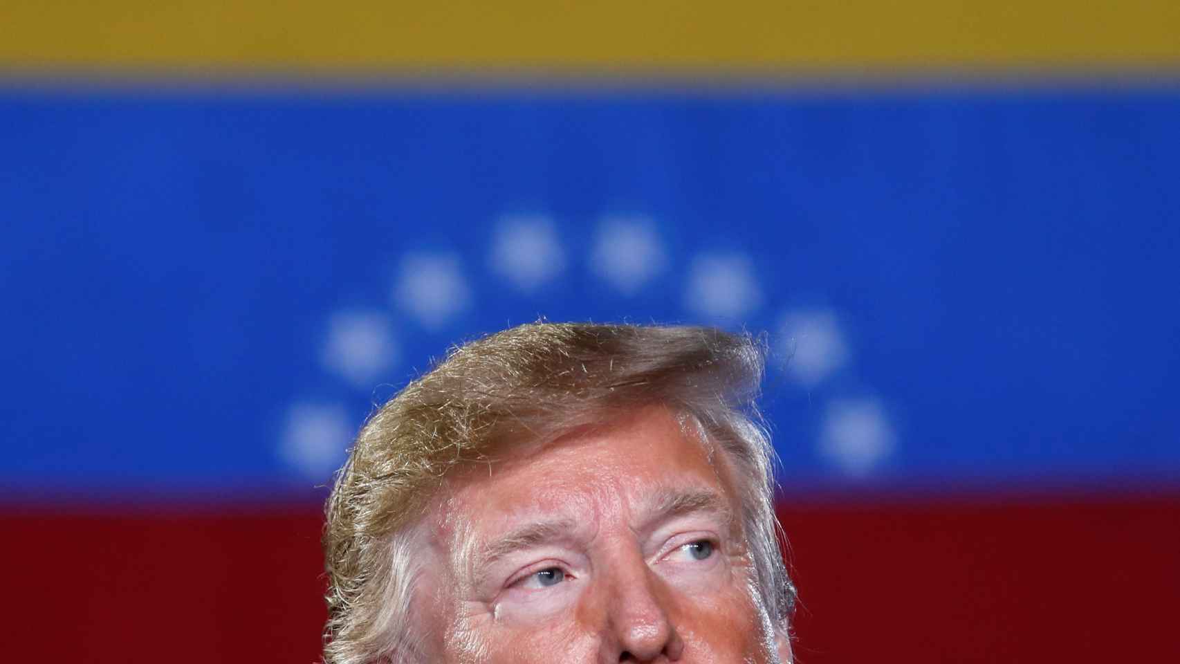 Donald Trump, presidente de Estados Unidos, con la bandera de Venezuela a sus espaldas.