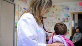 Una médica examina a un niño.