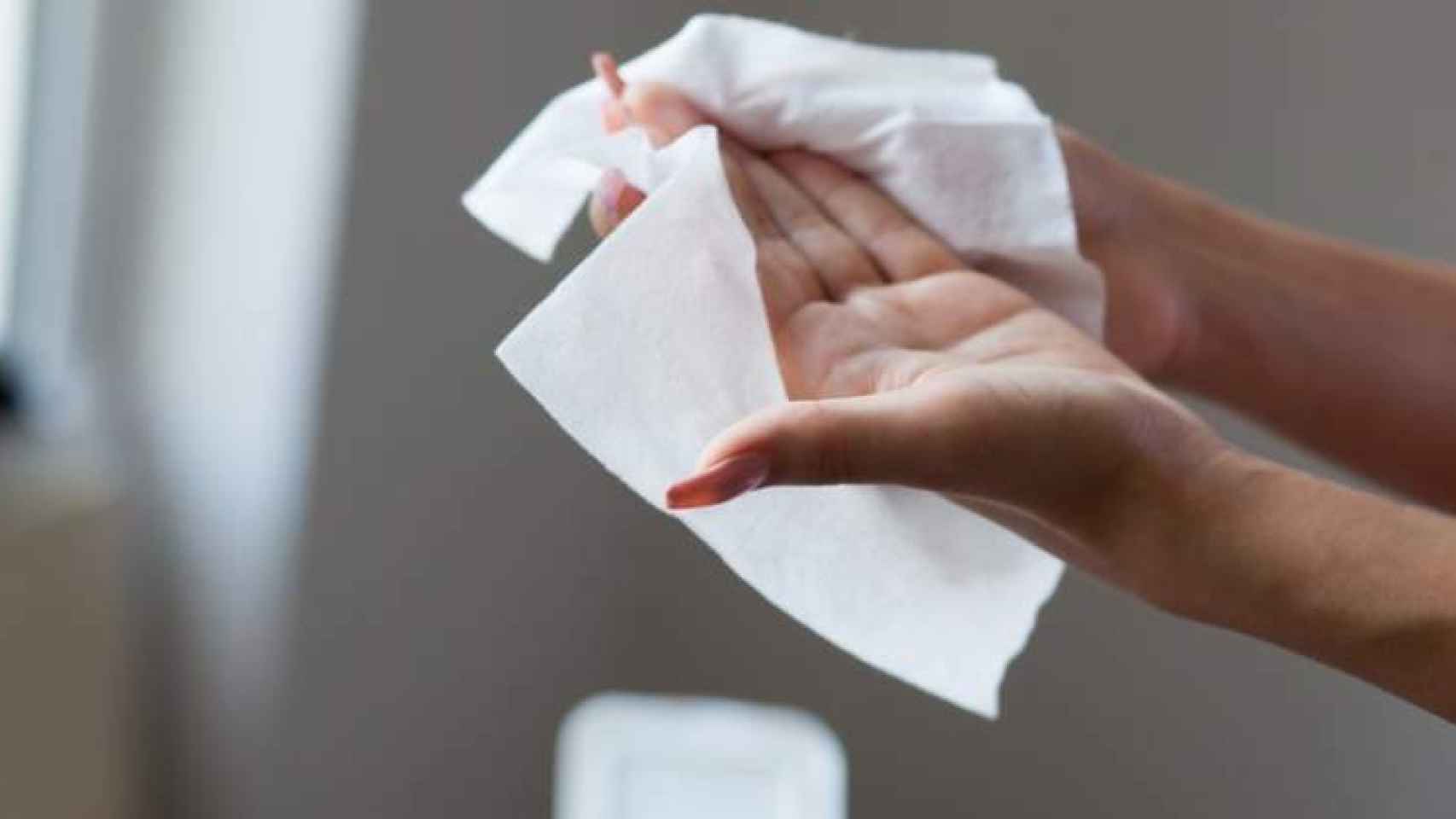 Una mujer se limpia las manos con unas toallitas.
