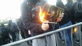 Un joven quema una fotografía del Rey en la protesta en el MWC