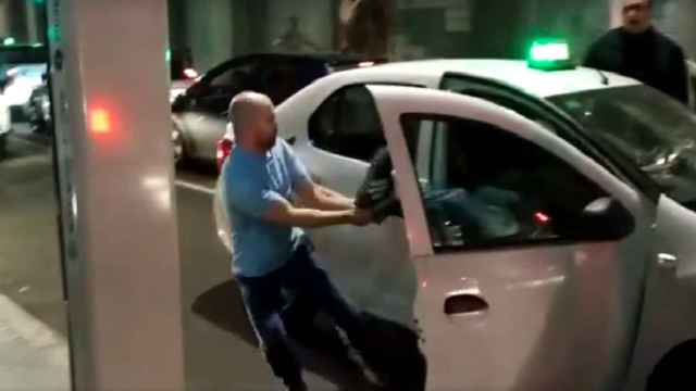 Captura del vídeo en el que se observa como el taxista intenta sacar a la fuerza al cliente de otro taxi.
