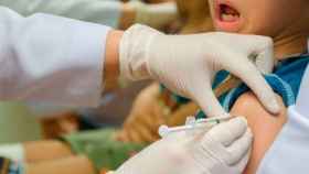 Enfermero vacunando a un niño.
