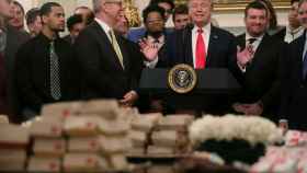Donadl Trump habla frente a la mesa de hamburguesas