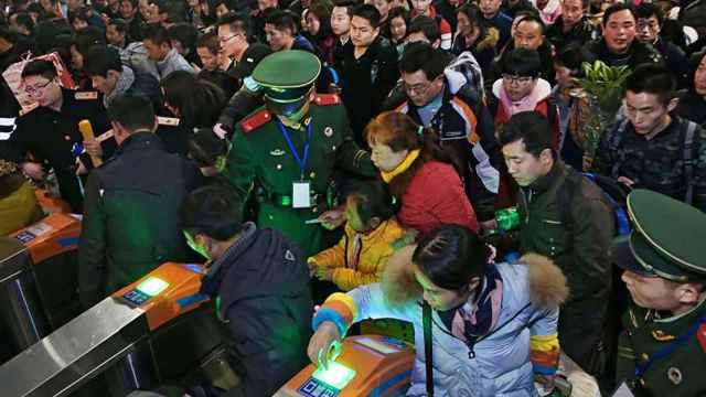 Viajeros pasando un control en estación de tren en China.