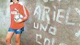 El pequeño Ariel, con 14 años y delante de una pintada que lo comparaba con Maradona