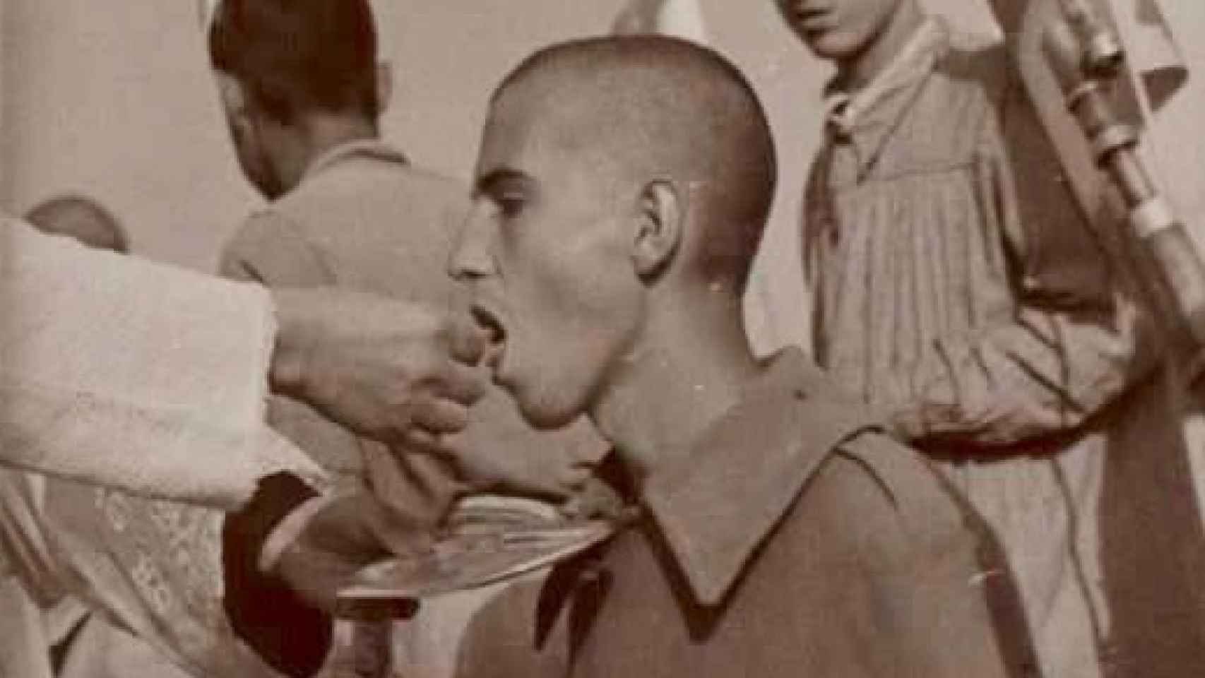 Prisionero menor de edad comulgando en el campo de concentración de Aranda de Duero.
